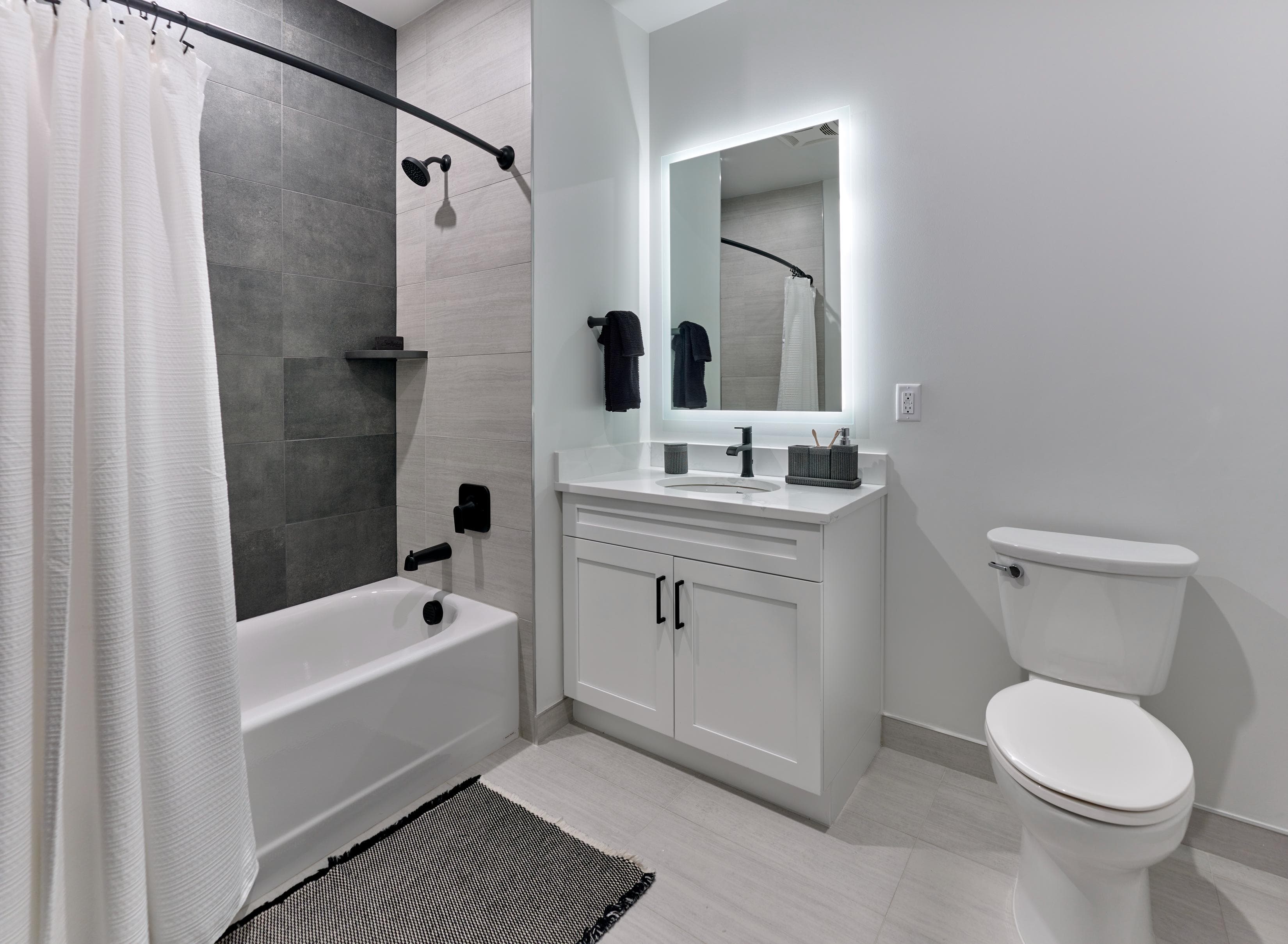 A white bathroom with a toilet, sink, and bathtub.