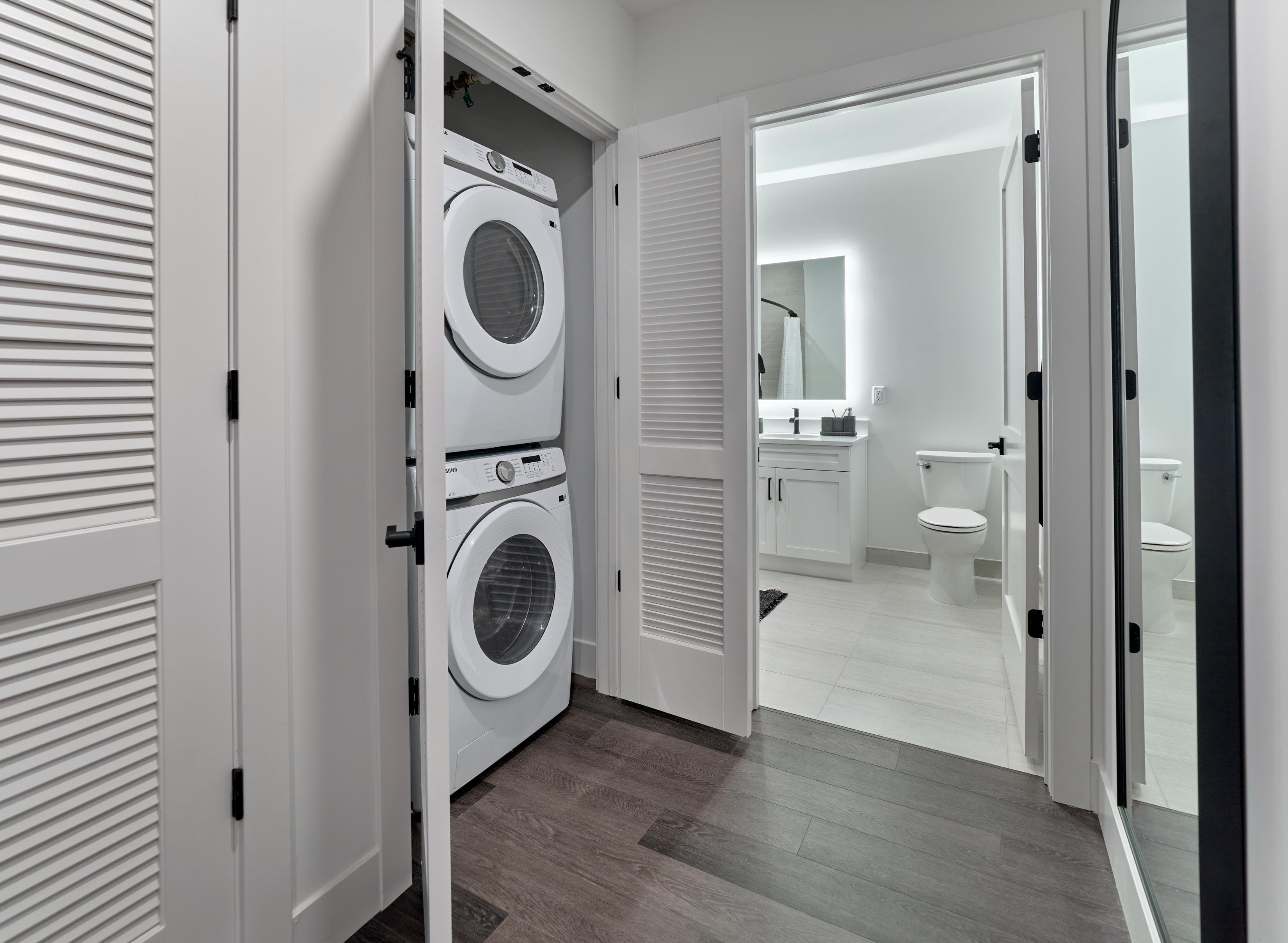 A white laundry room with a washer and dryer built into the cabinetry.