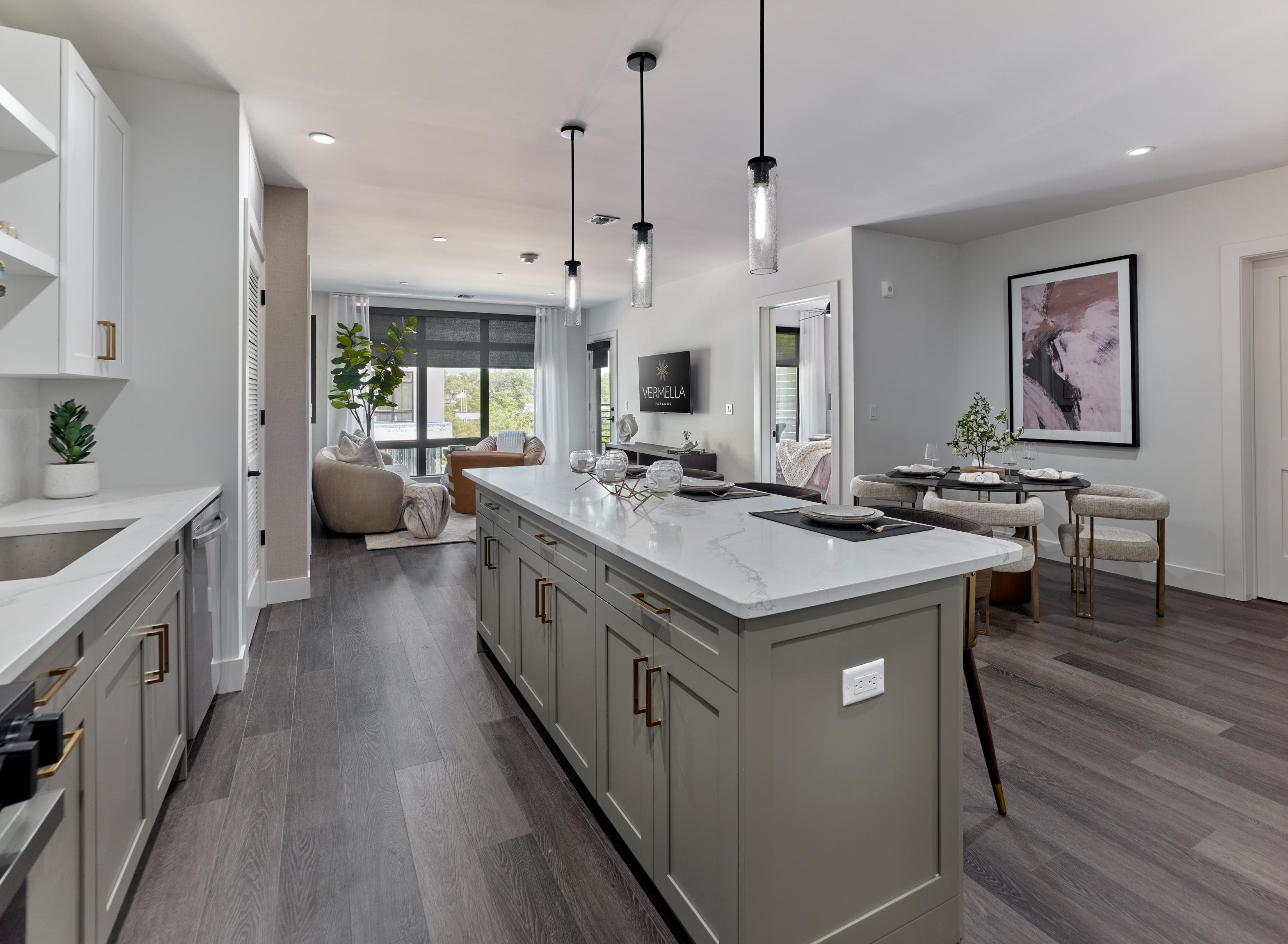 A modern kitchen with a large island and dark wood floors.