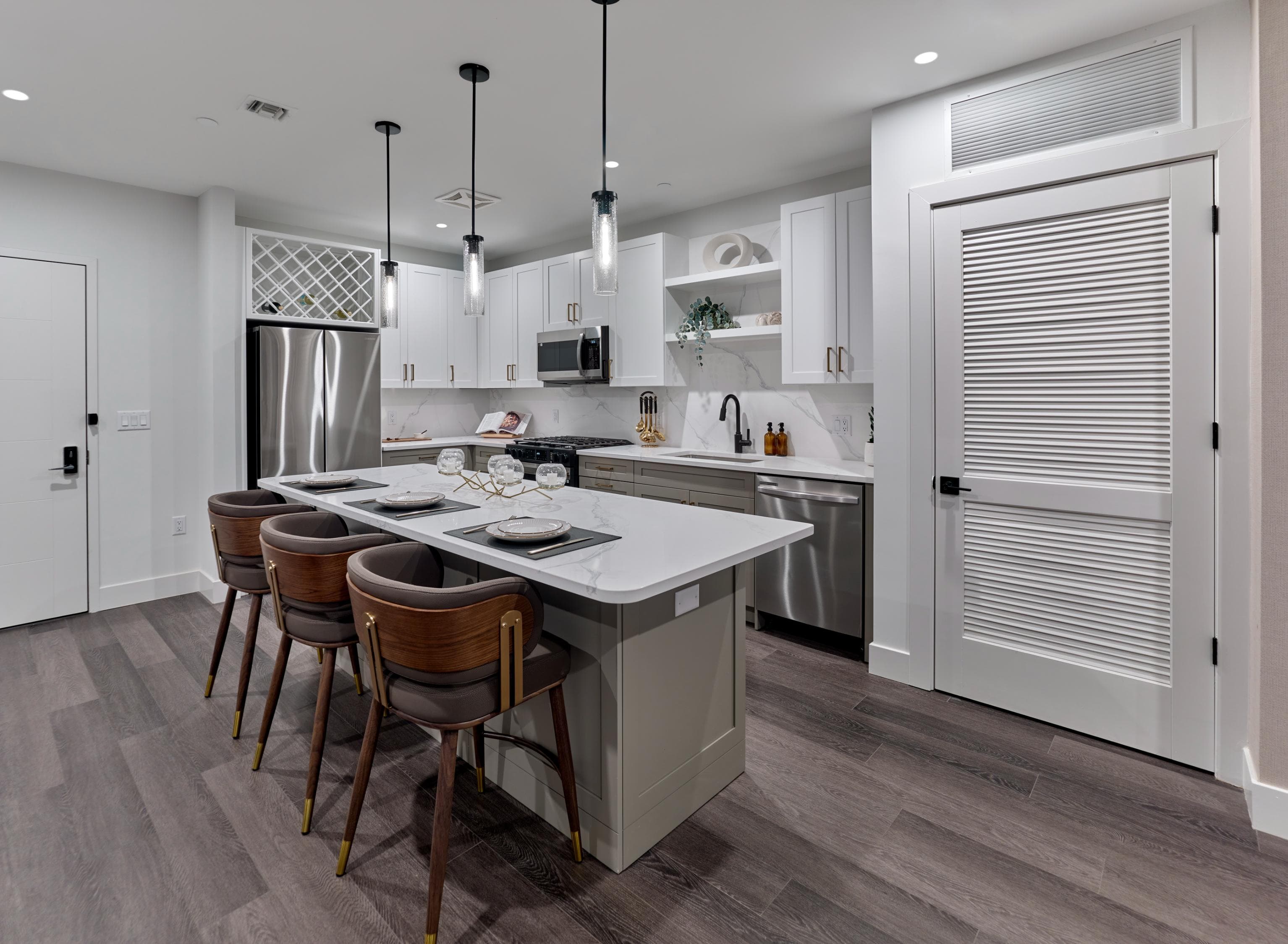A modern kitchen with a large island and barstools.