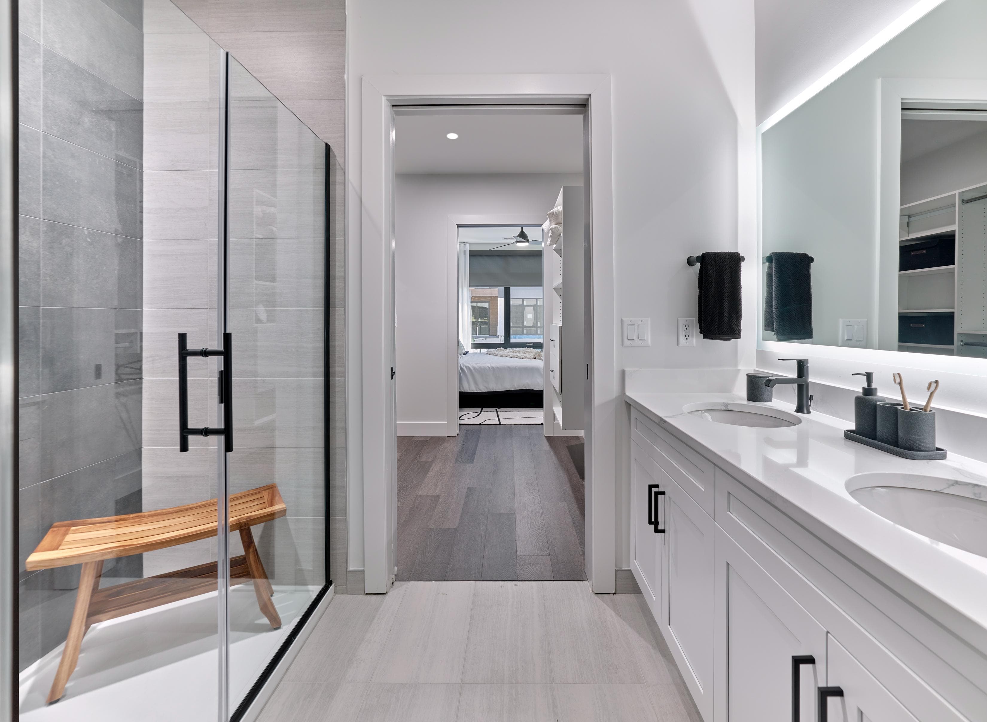 A modern bathroom with a walk-in shower and double sinks.