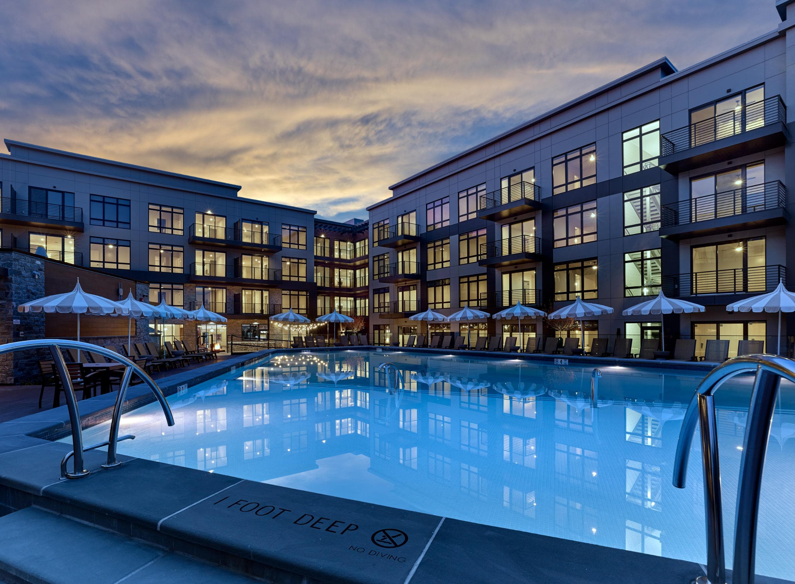 Vermella Paramus features a resort-style pool and sun deck surrounded by lounge and table seating, grill area, and fire pits.