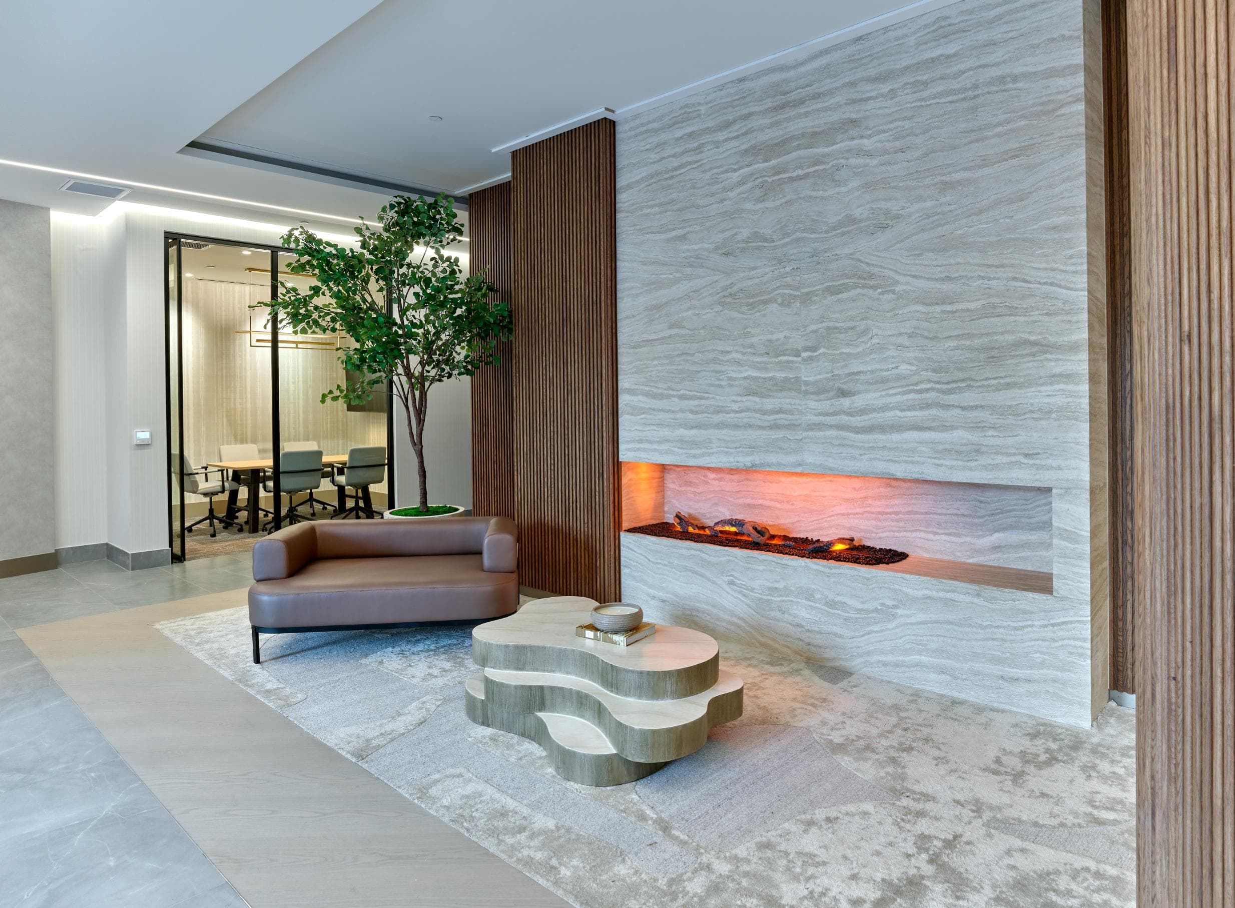 A modern living room with a fireplace and a brown sofa.