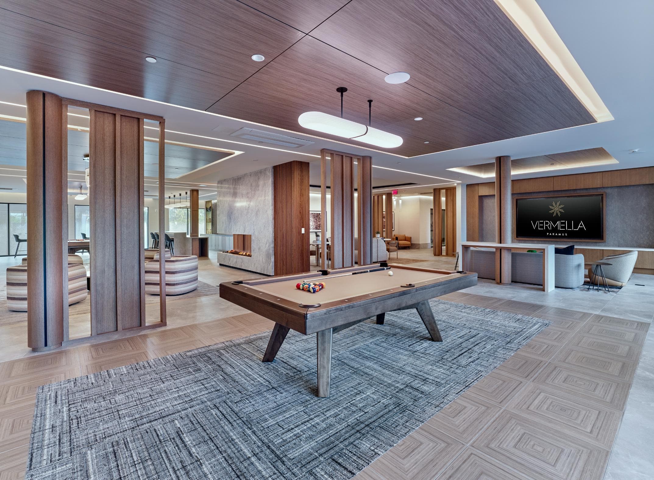 A pool table is in the middle of a room with a wooden floor and a sign that says