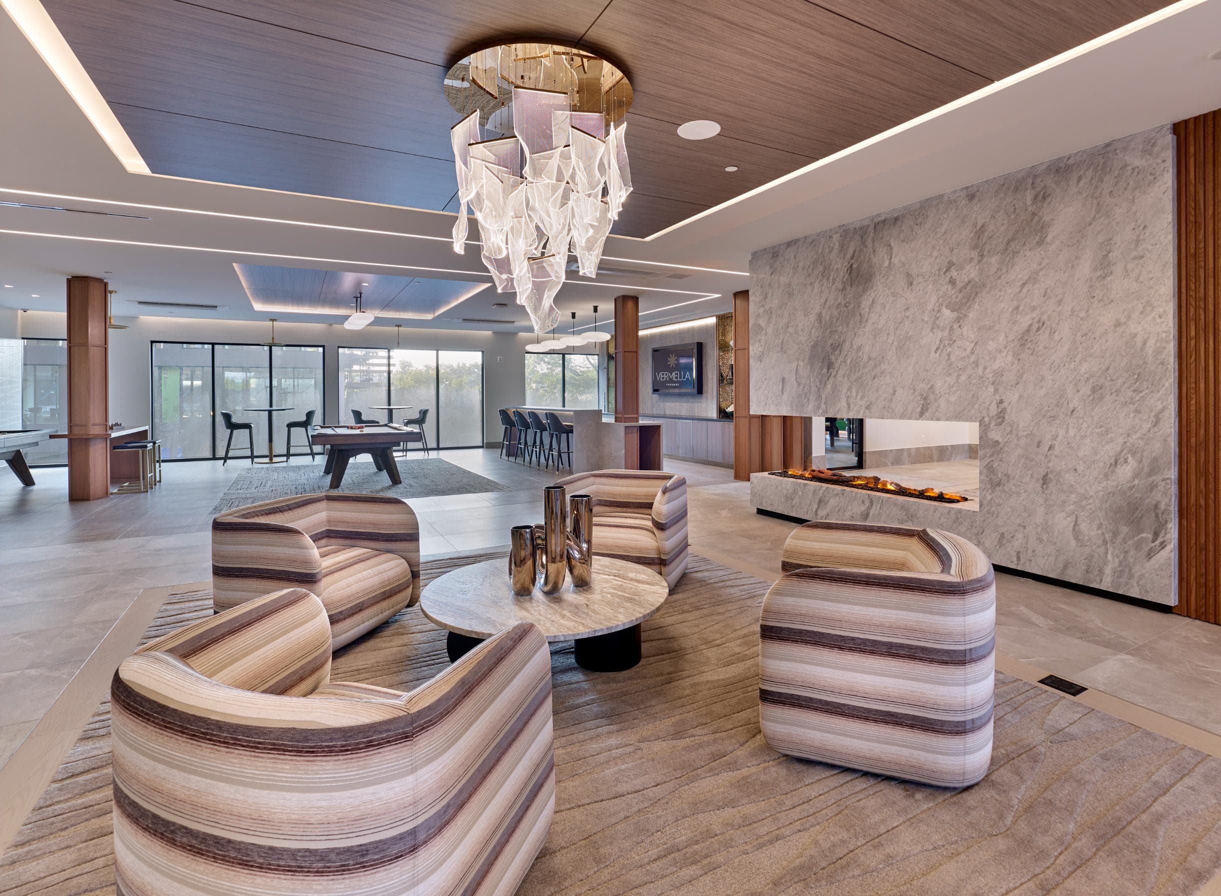 A modern living room with a striped sofa and a chandelier.