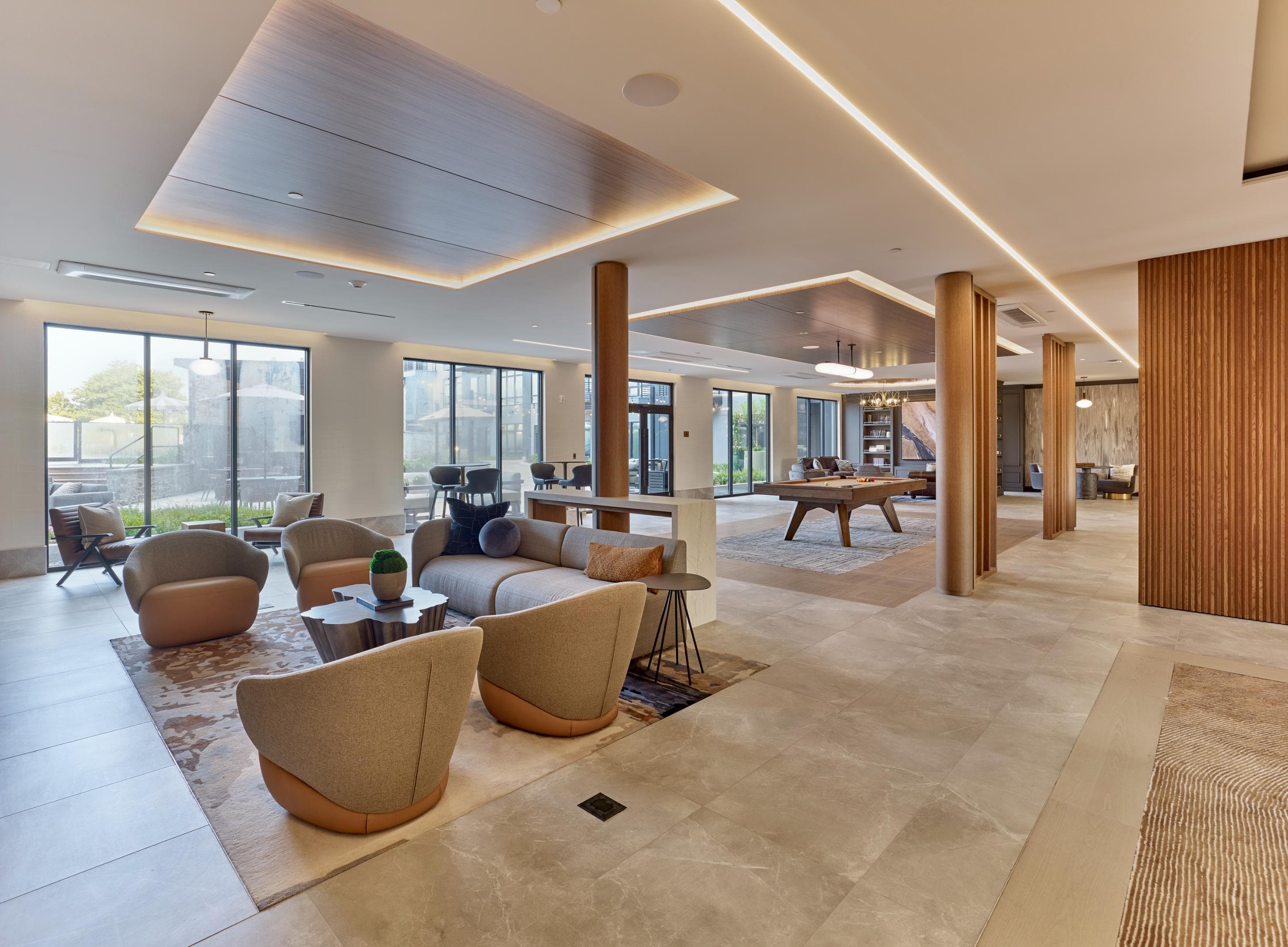 A spacious living room with a variety of seating options and a large window.